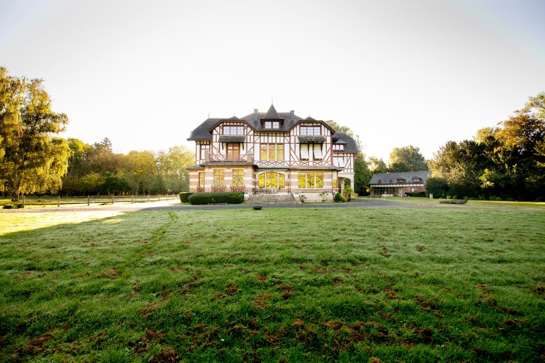 Domaine de la Nèle — the château framed by trees at the end of the front lawn